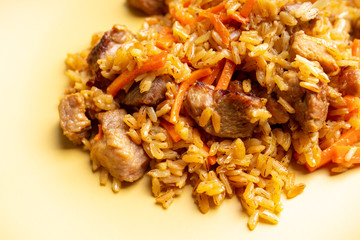 Traditional Uzbekistan pilaf on the rustic background. Selective focus. Shallow depth of field.