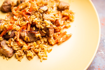 Traditional Uzbekistan pilaf on the rustic background. Selective focus. Shallow depth of field.