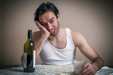 Drunk man gasping for the last drop in a wine bottle