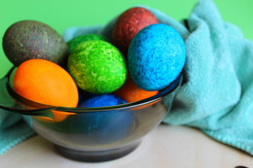 Marble eggs painted with speckles for Easter. in the dish next to the towel.