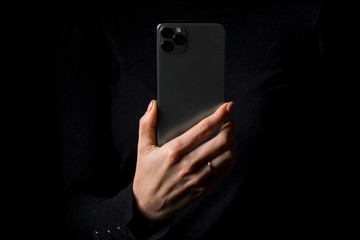 Person holding mobile phone vertically, photo isolated on black background