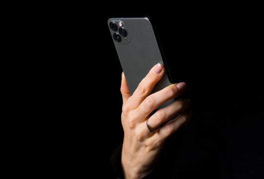 Person holding mobile phone, photo isolated on black background