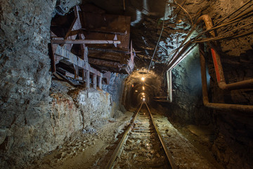 Fototapeta na wymiar Underground gold mine tunnel with ore chutes and light