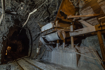 Underground gold mine tunnel with ore chutes and light