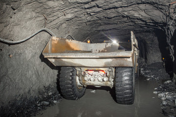 Dumper truck Minetruck Sandvik Toro Atlas Copco in underground mine tunnel