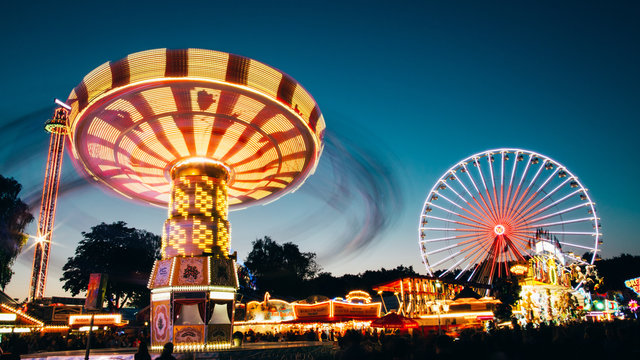 ferris wheel and chain carousel in amusement park at night