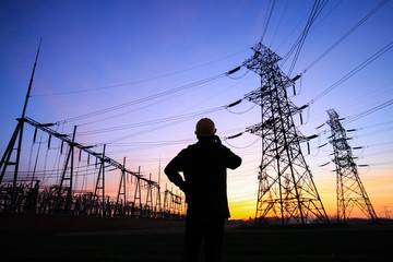 Fototapeta na wymiar Electricity workers and pylon silhouette, Power workers at work