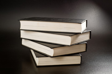 Books with black covers shot on a dark background. Background for study, reading and science.