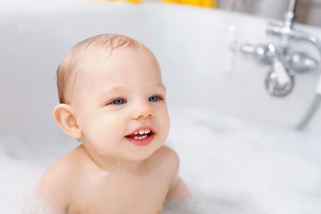 Portrait of happy baby boy sitting in bathtub
