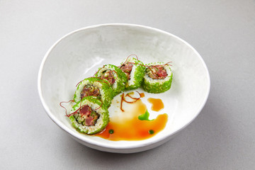 sushi uramaki with fish, green seaweed with sauce