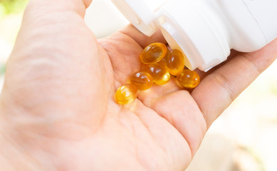 Fish oil is poured from the jar into the hand.
