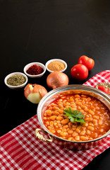 traditional turkish food dried beans on a copper plate with vegetables next to it