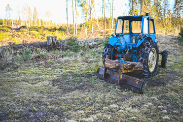old blue tractor with plow waiting for snow