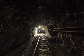 Fototapeta na wymiar Underground gold mine shaft tunnel drift with rails and light