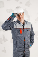 Portrait of a Builder on a rough concrete wall. Concept of construction and repair.