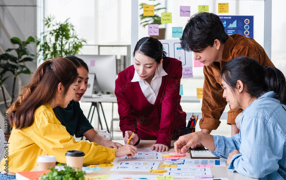 Poster ux developer and ui designer brainstorming about mobile app interface wireframe design on meeting table with customer brief and color code at modern office.Creative digital development agency