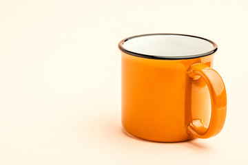 An empty iron mug on a yellow background
