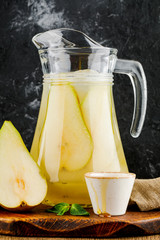 jug with pear juice, honey and mint on wooden tray