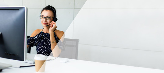 Beautiful consultant of call center in headphones.  Portrait of smiling female customer using headset at call center office. panomamic banner space text design.