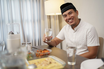 asian man with traditional muslim clothes breakfasting dinner at home
