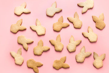 Easter bunnies shaped cookies on pink background. Top view.