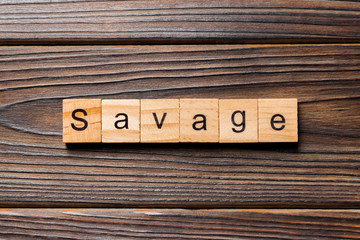 SAVAGE word written on wood block. SAVAGE text on wooden table for your desing, concept