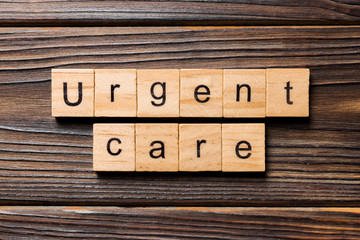 Urgent care word written on wood block. Urgent care text on wooden table for your desing, concept