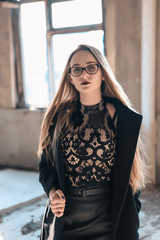 insanely beautiful girl with glasses in an abandoned building