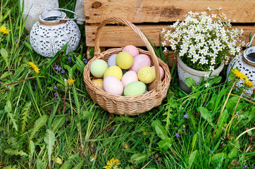 Wicker basket with Easter eggs in the garden.