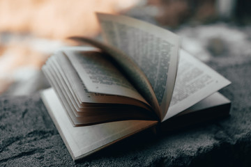 a book open on a concrete surface