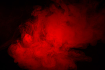 Colorful smoke close-up on a black background. Red cloud of smoke.
