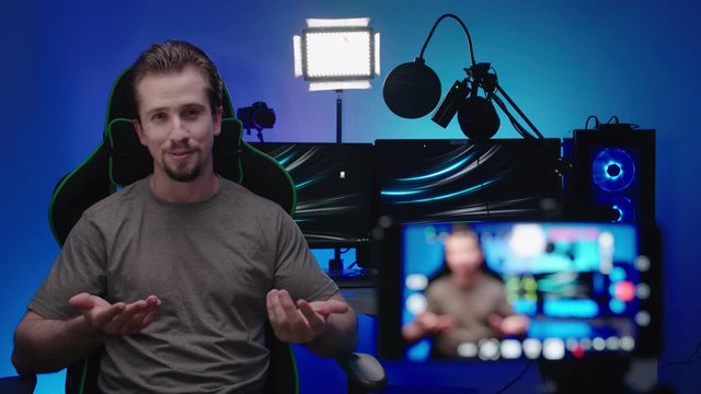 Person with gaming computer in background recording video 4K