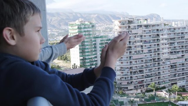 Family applauding medical staff from their balcony. People in Spain every evening clapping on balconies and windows in support of health workers during the Coronavirus pandemic