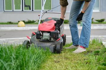 Working lawn mower on green lawn with trimmed grass