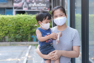 Single mom with kids boy in face mask outdoor city. Mother and child wear facemask during coronavirus and flu outbreak.