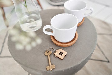 Stay home. House key and keychain in the form of homes lies on concrete table. Concept for real estate, mortgage, moving home or renting property. Bed and Breakfast