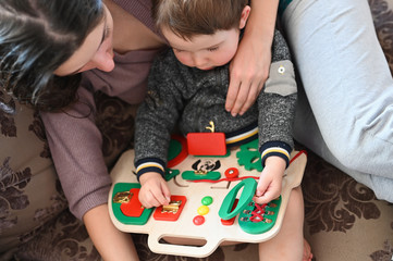 Mom plays with a child on a development board. child development.