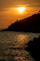 silhouette of a lighthouse in Circeo national park at sunset. Latina, Lazio, Italy