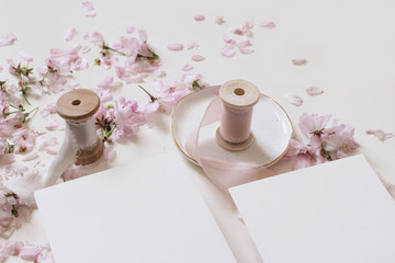 Wedding spring mockup scene with pink blossoming Japanese cherry tree branches, petals and silk...