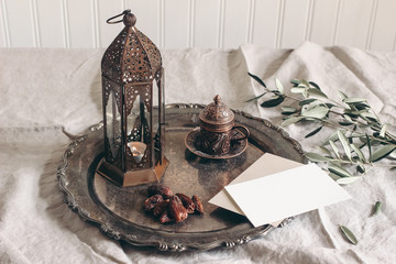 Ramadan Kareem greeting card, invitation mockup scene. Bronze plate with dates fruit, cup of tea,...