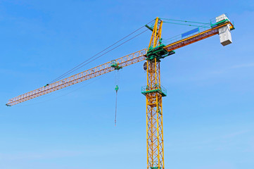yellow construction crane tower on background sky