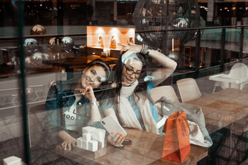 Cafes and bars. Two girls are sitting at a cafe table. Discussion of shopping. Girlfriends in a cafe.