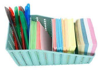 stack of colored paper, colored pens and basket for pens