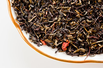 A mixture of black and green tea with vanilla-strawberry flavor, sliced strawberries and rose petals. Background for tea and antioxidants.