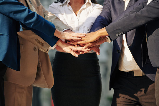 Business team stacking hands to express support and unity