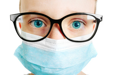 Face of a mask-wearing boy with fear in the eye Close-up on a white background.Coronavirus and Air pollution pm2.5 concept