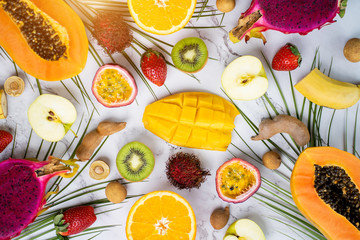 Exotic fruits and tropical leaves on table