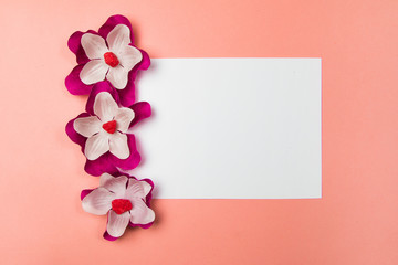 White and purple flowers with blank white page on a pastel background