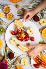 Exotic fruits and tropical leaves on table