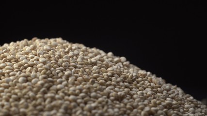 White beautiful quinoa strew on a black background. Quinoa is healthy and sport product for dishes.